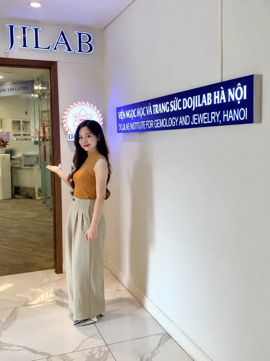 Đại diện Pancharm đứng trước biển Viện Ngọc học và Trang sức DOJILAB Hà Nội